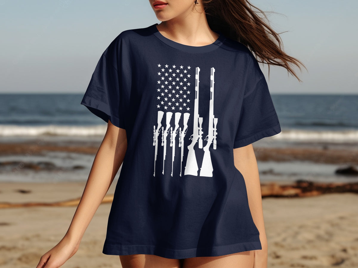 Navy t-shirt with an American flag graphic made of rifles on a beach.