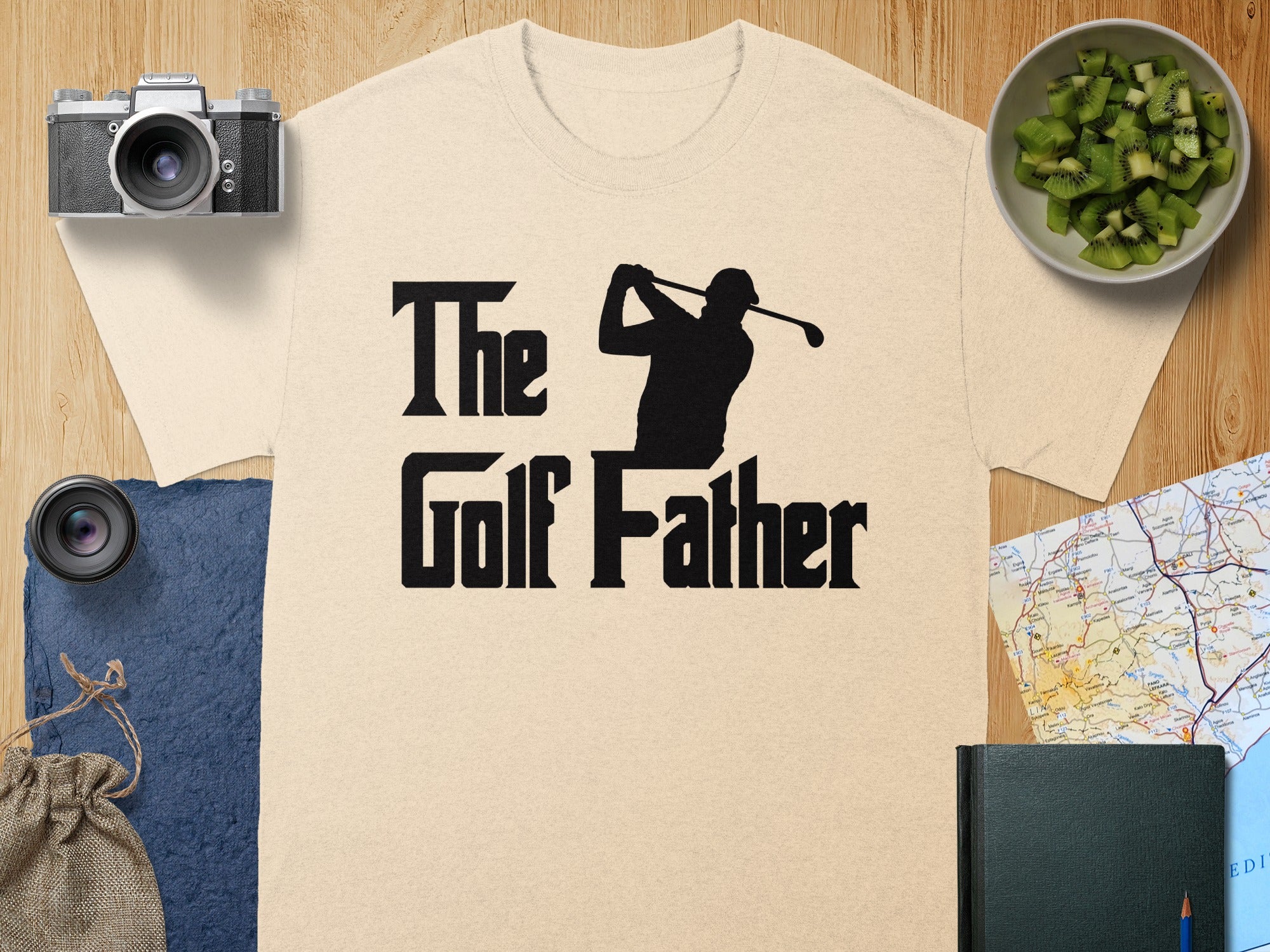 Beige t-shirt with black text "The Golf Father" and a golfer silhouette.