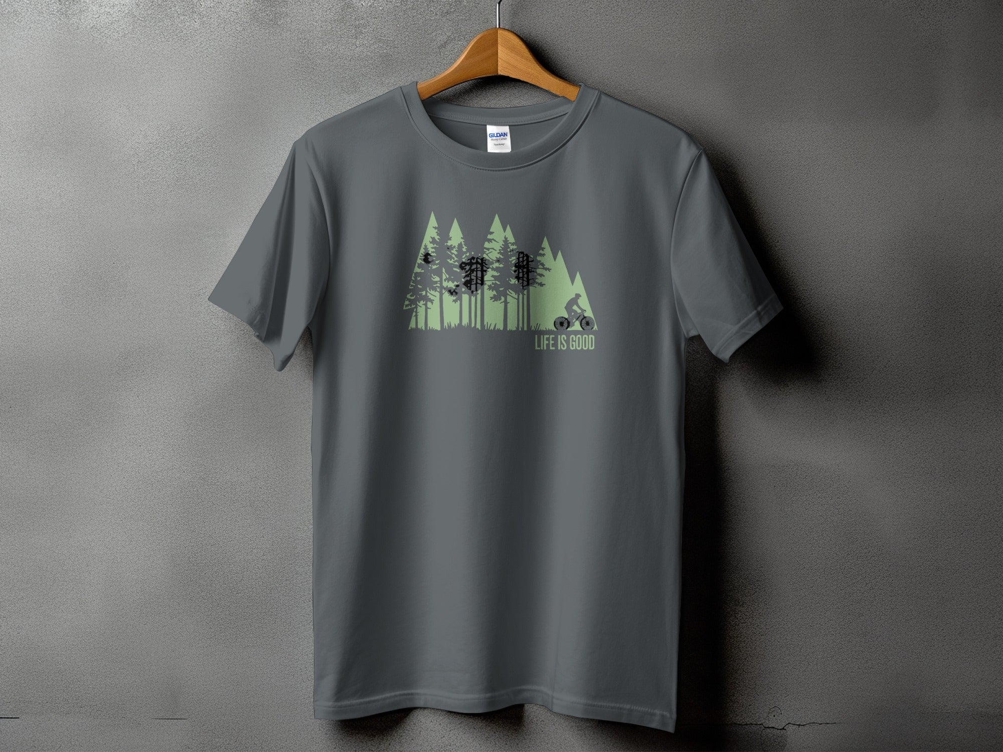 Gray t-shirt with green forest graphic and cyclist, reads "LIFE IS GOOD".