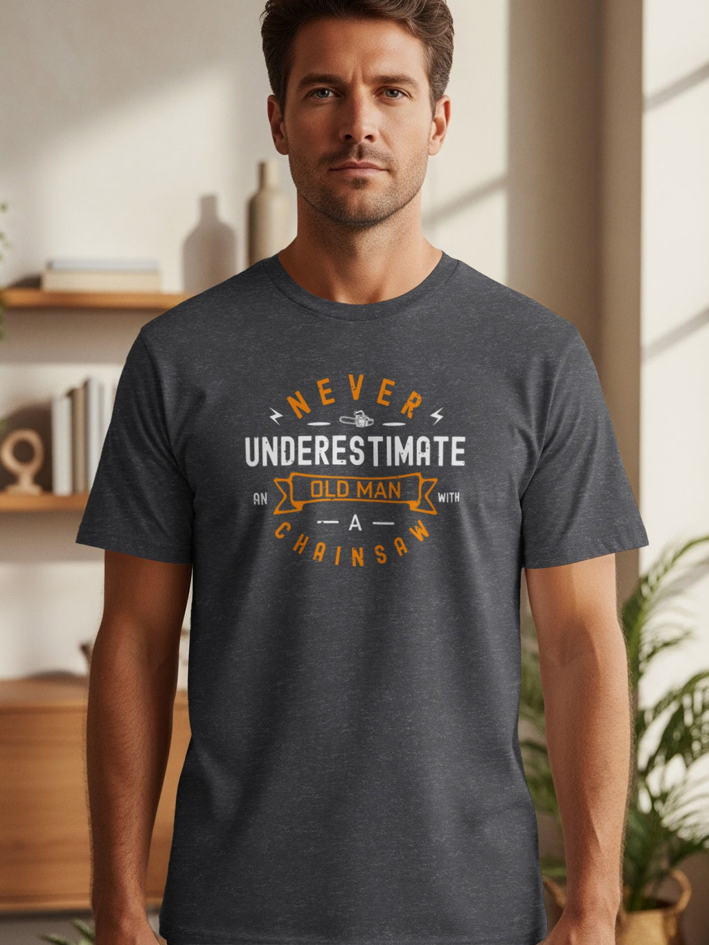 Dark grey t-shirt with "Never Underestimate an Old Man With A Chainsaw" text design.