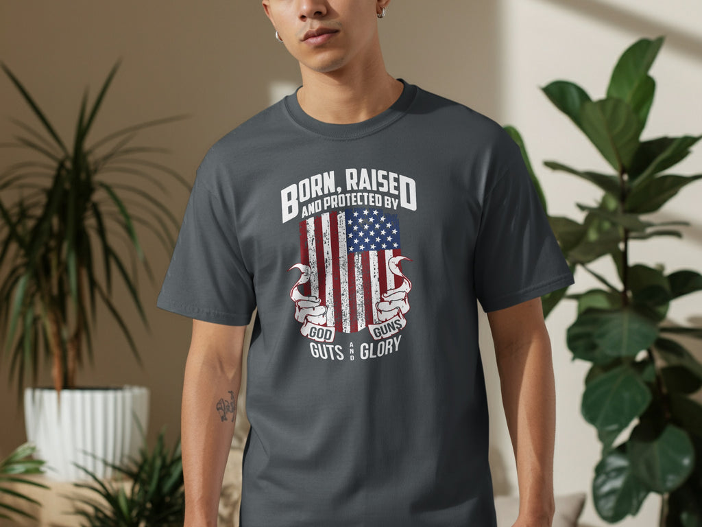 Dark grey t-shirt with American flag design and text: Born, Raised, Protected by God, Guts, Guns & Glory.