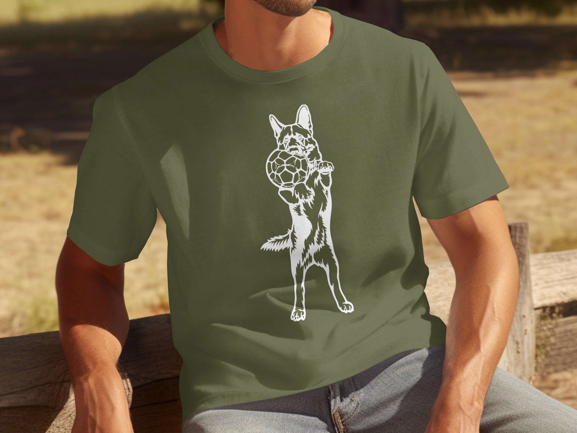 White outline of a dog holding a soccer ball on a green t-shirt.