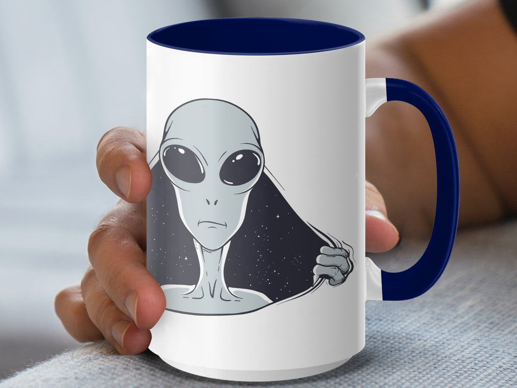 White mug with blue handle featuring a gray alien peeking through torn fabric design.