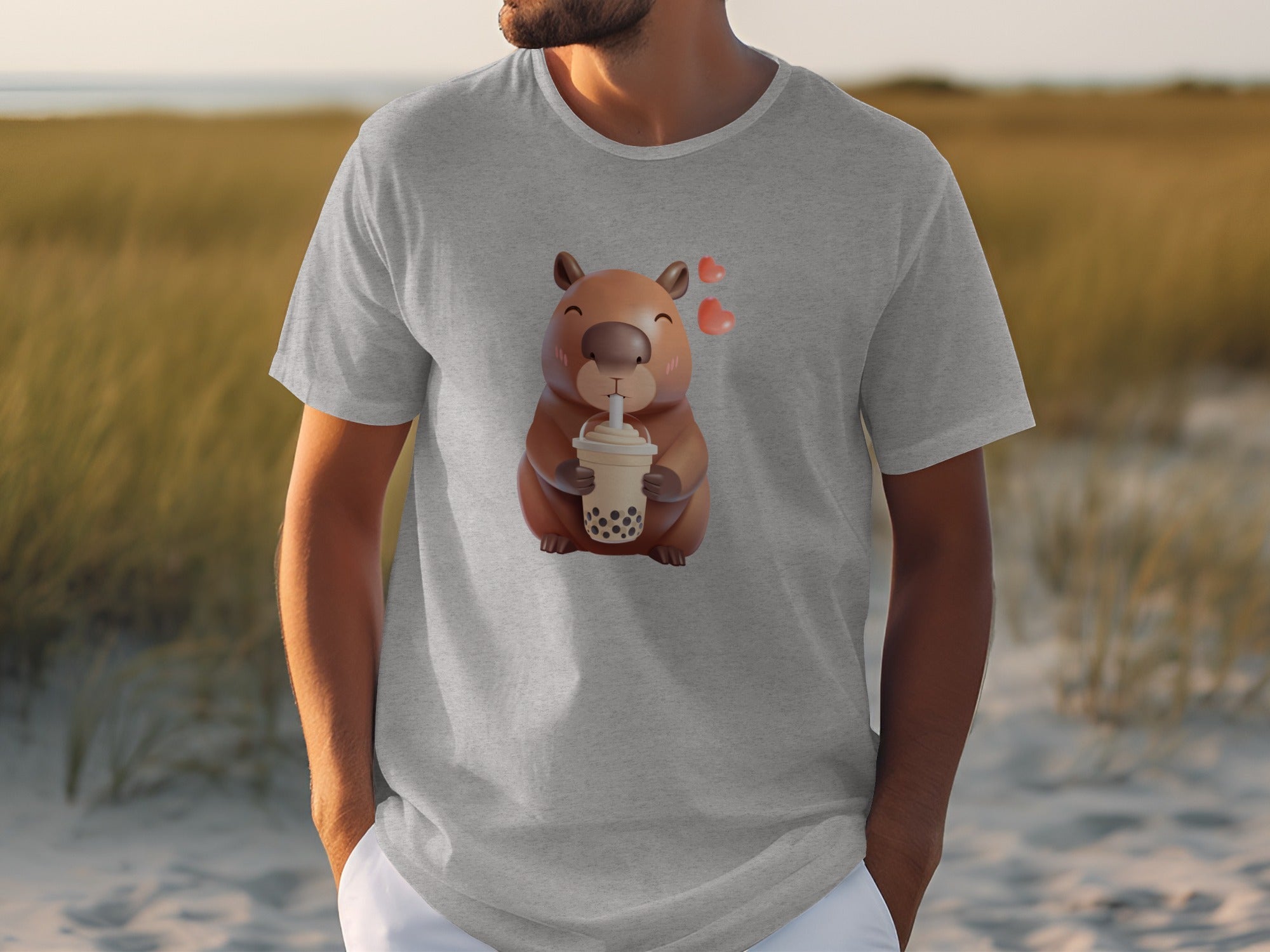 A man wearing a grey t-shirt featuring a cartoon capybara drinking boba.