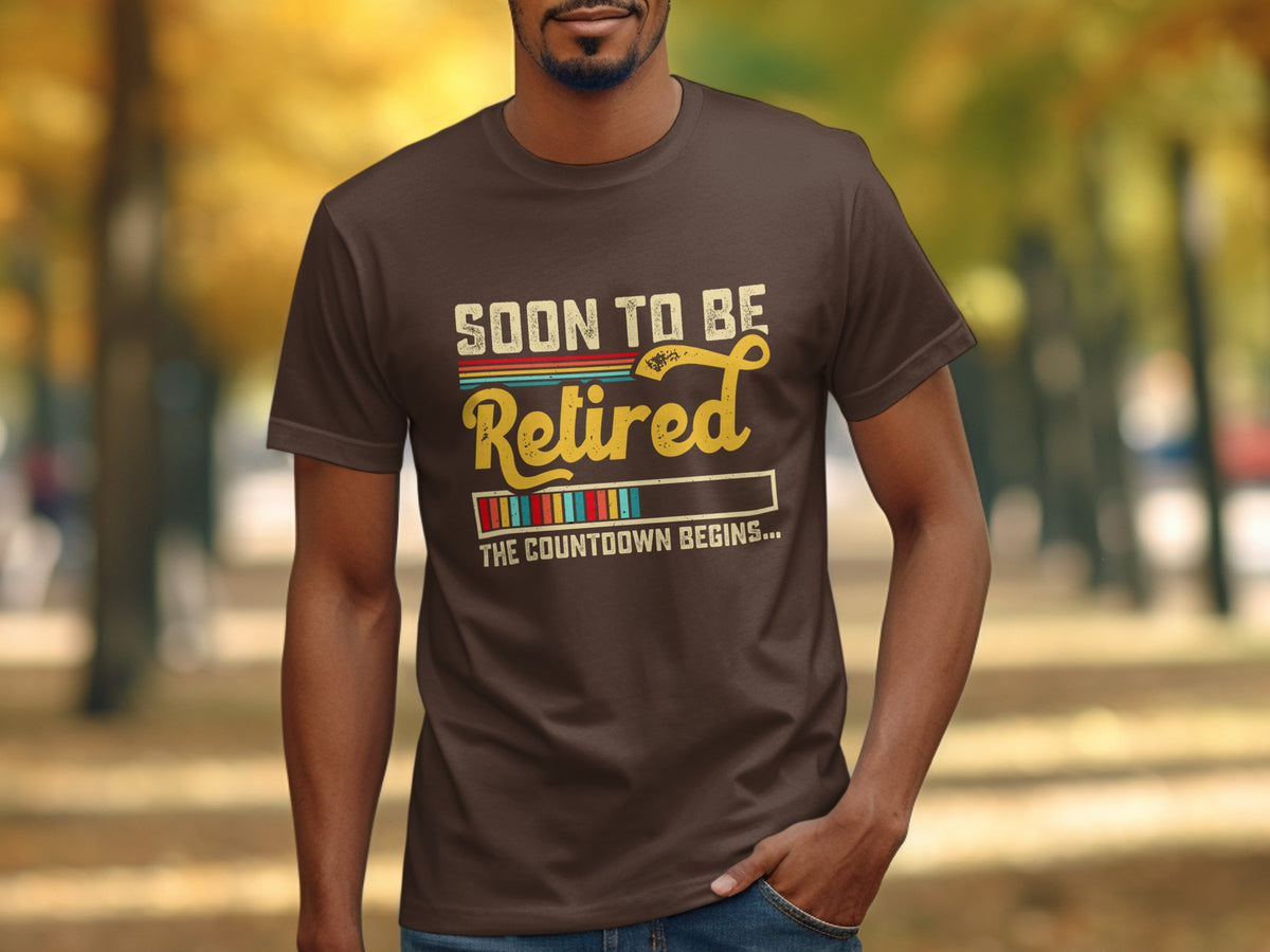 Brown t-shirt with text "SOON TO BE Retired THE COUNTDOWN BEGINS..."