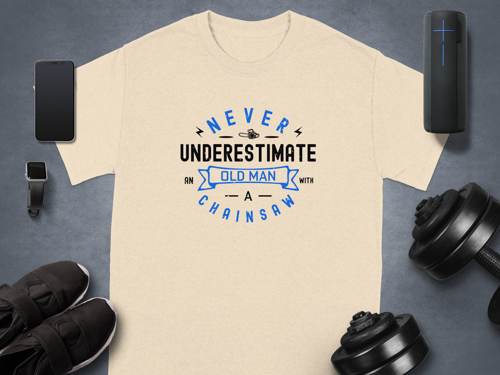 Cream t-shirt with text "NEVER UNDERESTIMATE AN OLD MAN WITH A CHAINSAW".