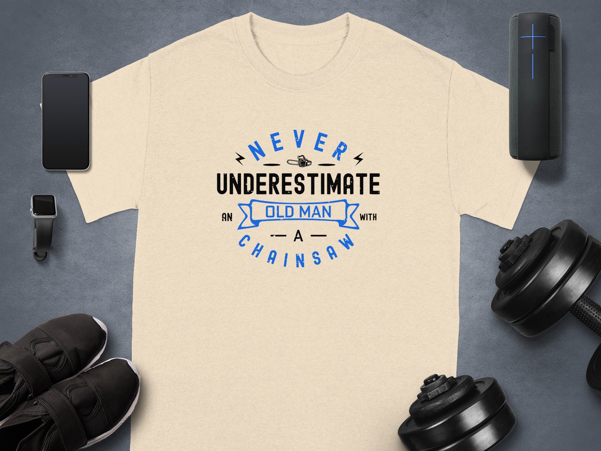 Cream t-shirt with text "NEVER UNDERESTIMATE AN OLD MAN WITH A CHAINSAW".