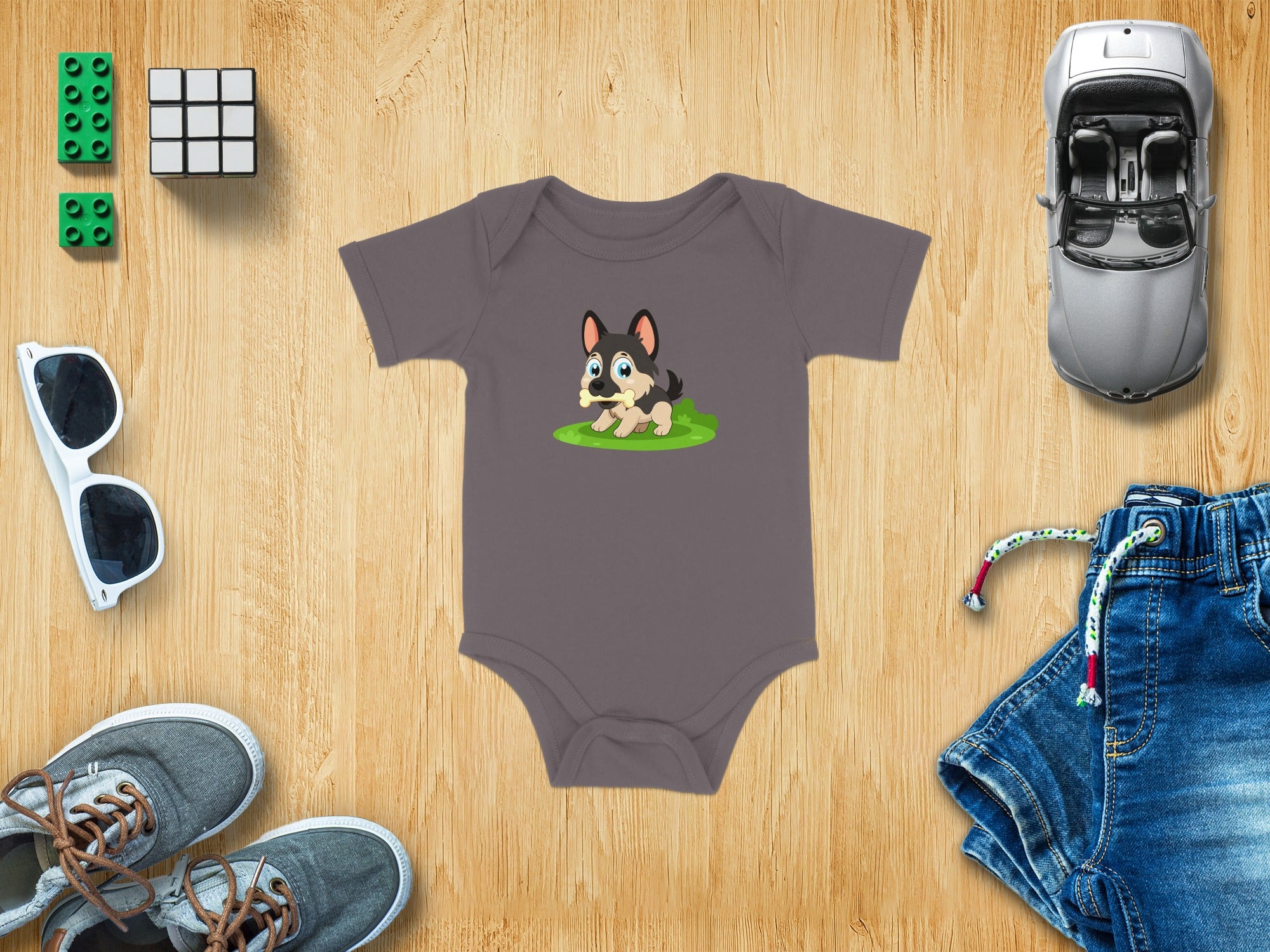 Gray baby onesie with a cartoon German Shepherd puppy holding a bone.