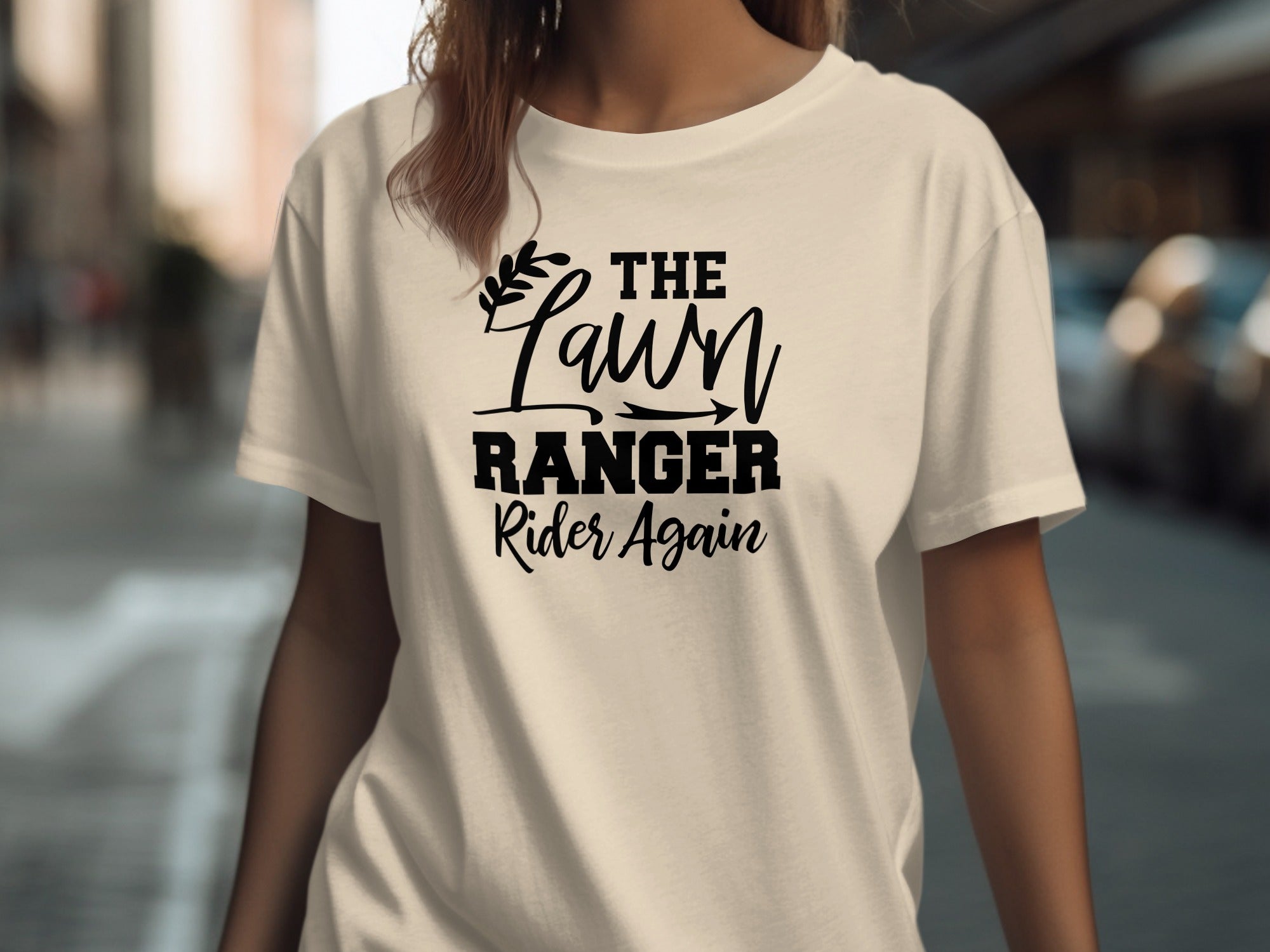 Cream t-shirt with black text "The Lawn Ranger Rider Again" and a leafy accent.