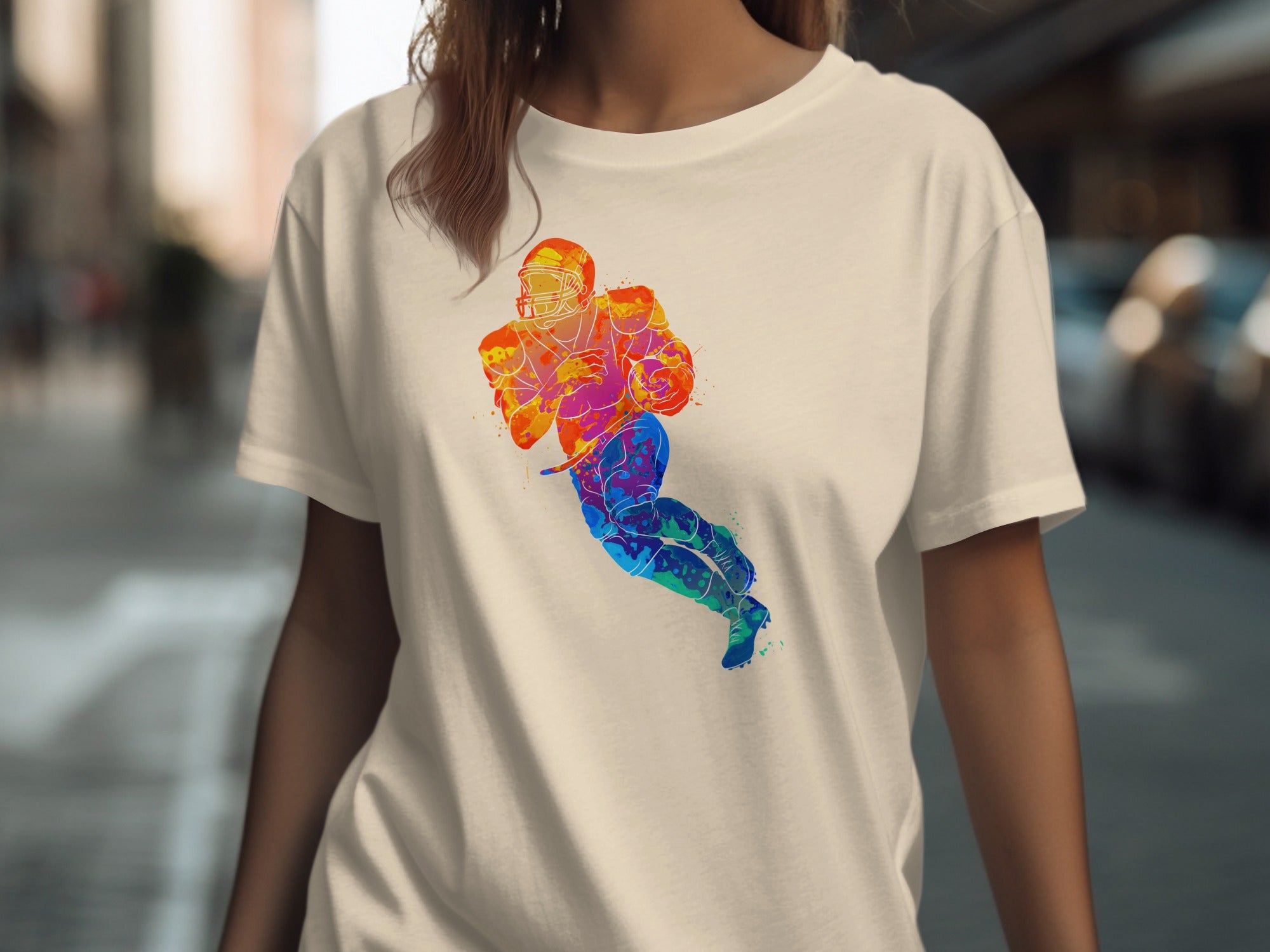 Cream t-shirt with watercolor football player graphic in vibrant colors.