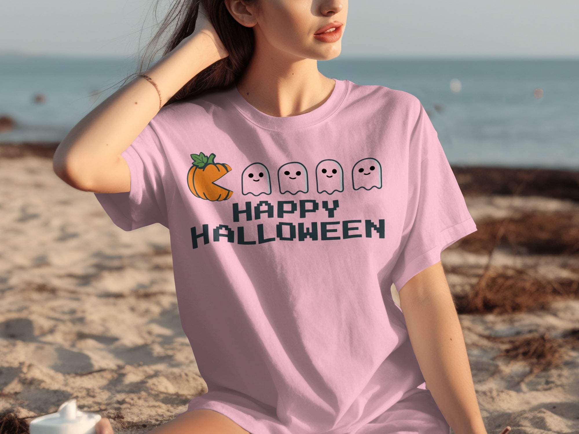 Pink t-shirt with a pixelated pumpkin, ghosts, and "Happy Halloween" text.
