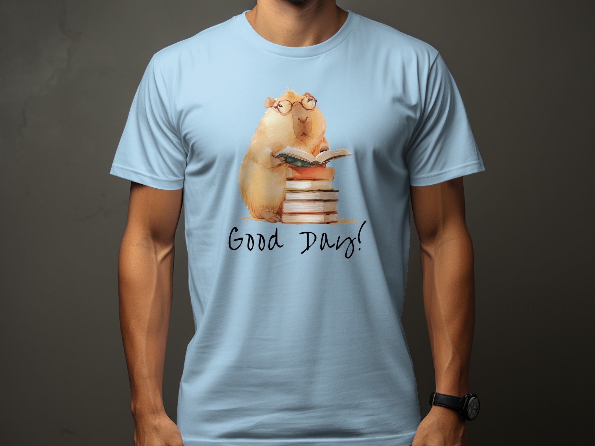 Light blue t-shirt with watercolor illustration of a capybara reading a book.