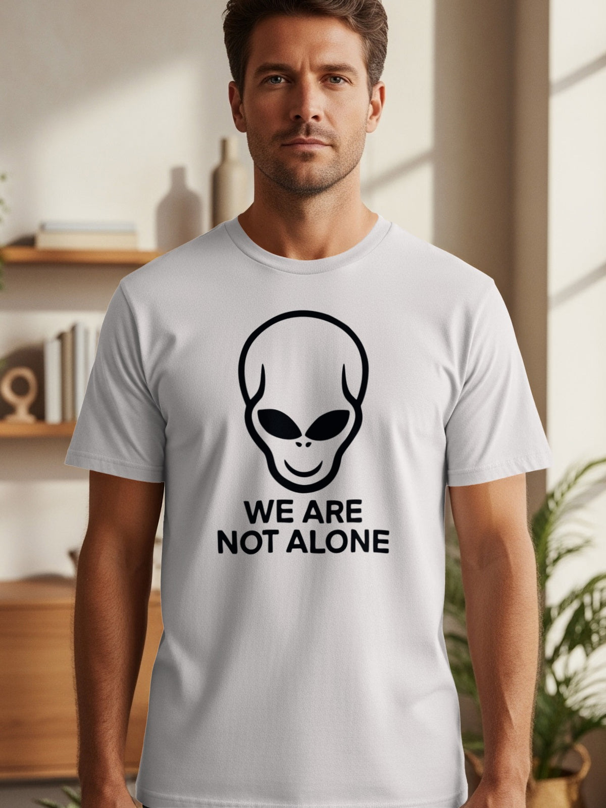 Light gray t-shirt with black alien head graphic and "WE ARE NOT ALONE" text.