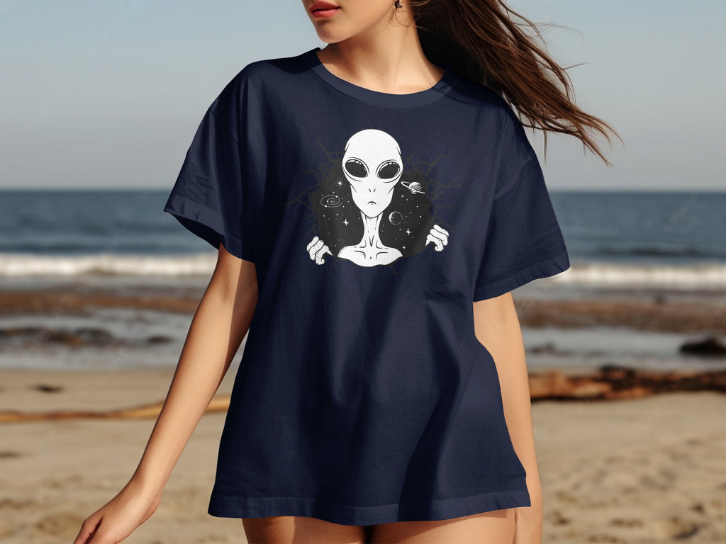 Dark blue t-shirt with a white alien emerging from a cracked celestial background.