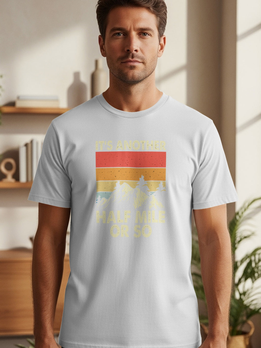 Light gray t-shirt with retro graphic text "IT'S ANOTHER HALF MILE OR SO".